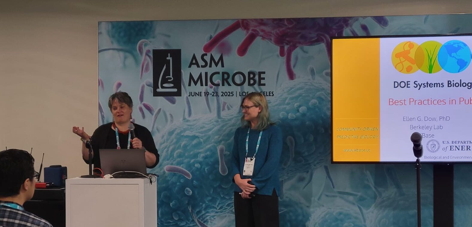 Vanja Klepac-Ceraj and Ellen Dow standing at the front of the session space with slide deck screen on the right hand side.