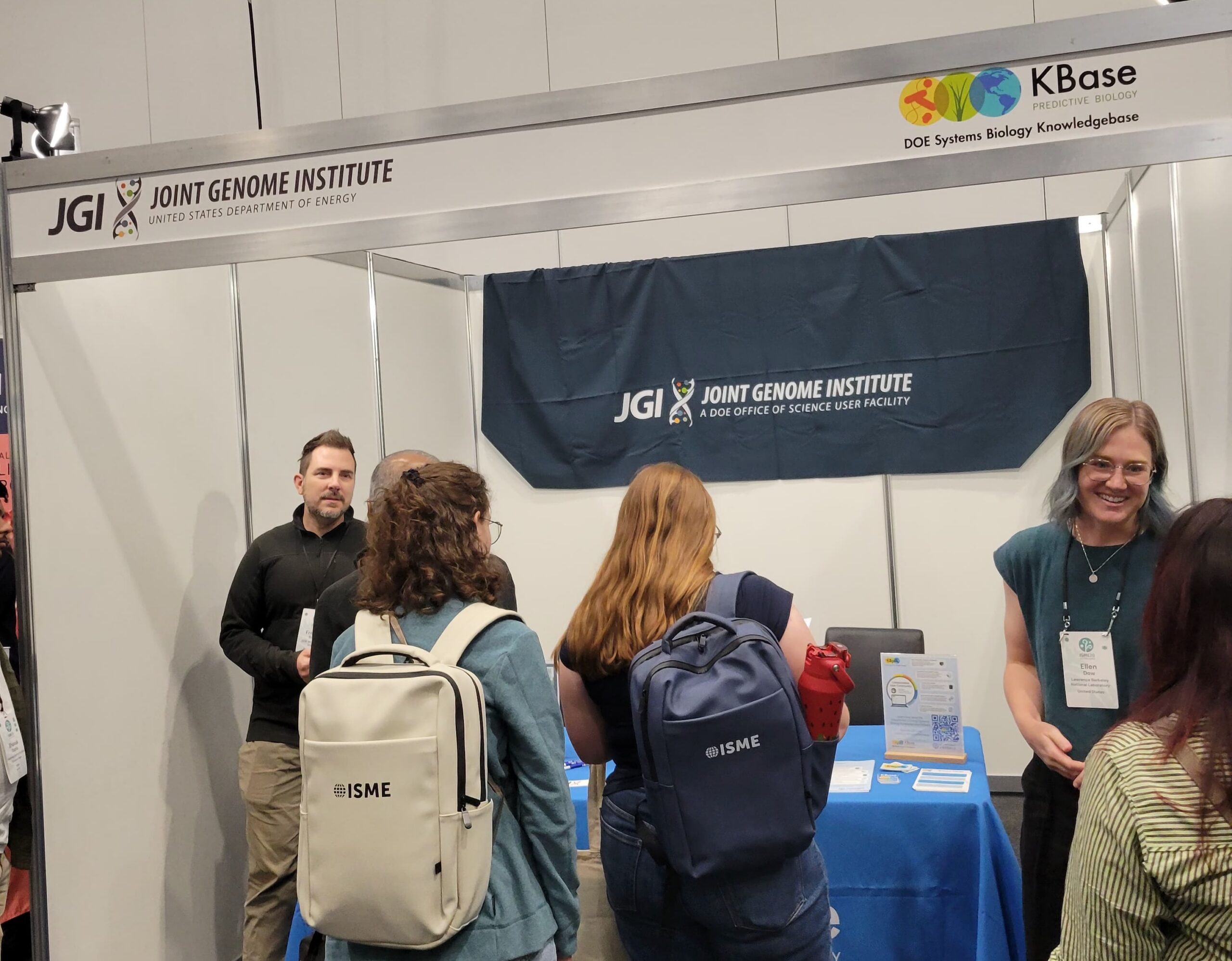 People talking at the KBase and JGI Booth at ISME20.
